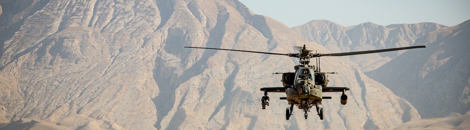 military helicopter flying in the desert