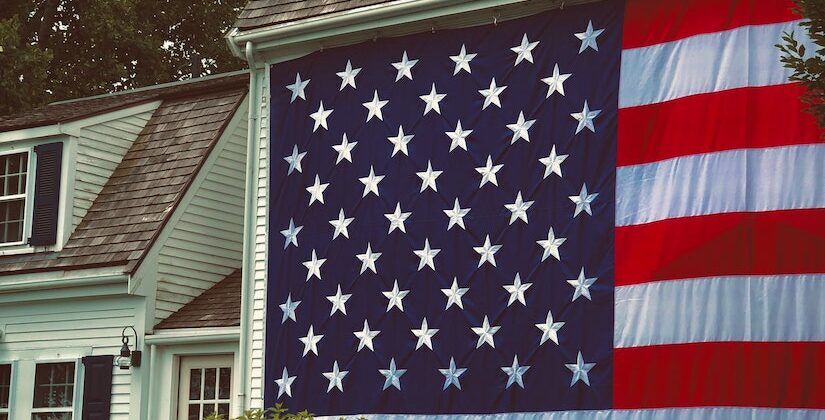 Large American flag hung on the outside of a house